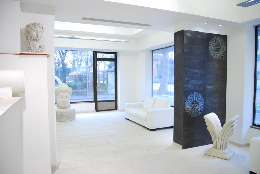 a living room with a white couch and sculptures at City of Art Venice LLoyd in Marghera