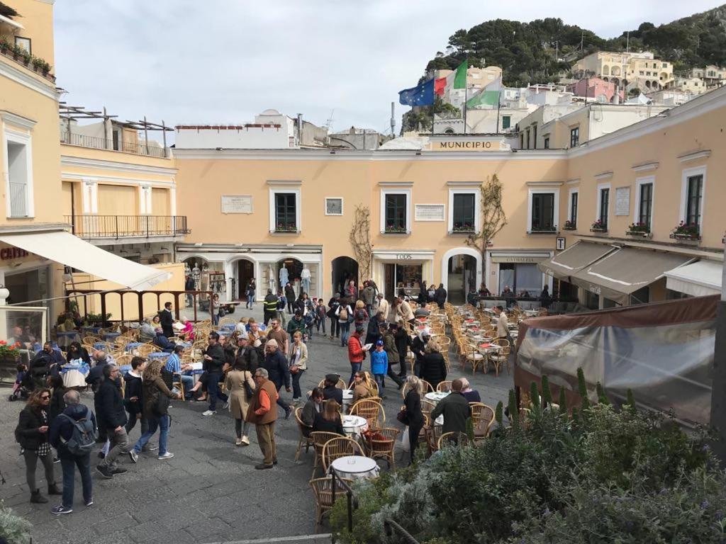 a crowd of people standing around in a courtyard at Piazzetta House in Capri