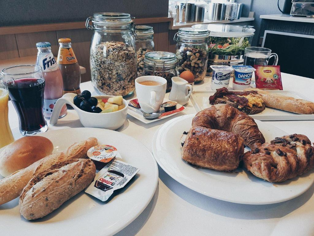 a table with two plates of bread and pastries at Biznis Hotel in Lokeren