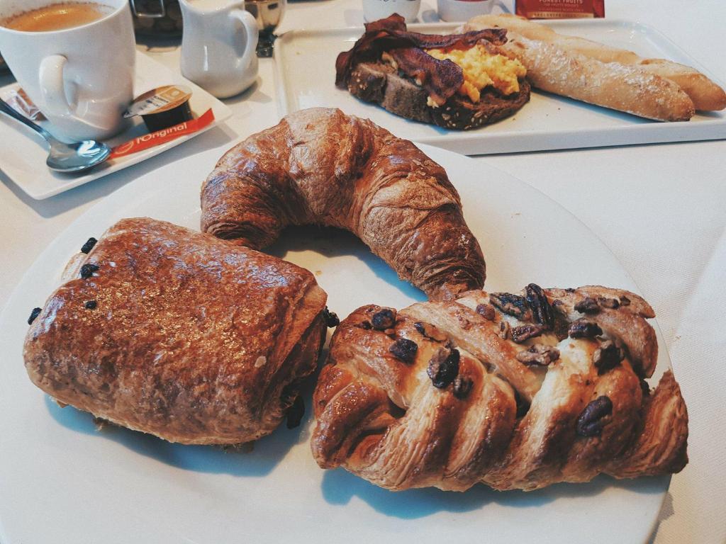 a plate of pastries and croissants on a table at Biznis Hotel in Lokeren