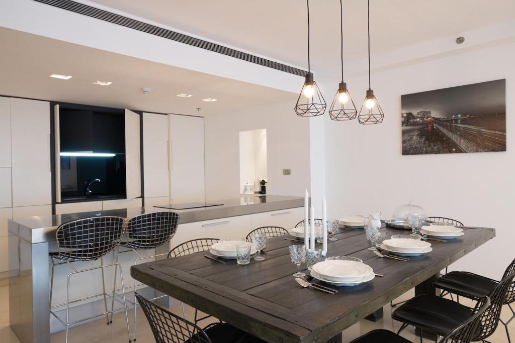 a dining room with a wooden table and chairs at High Class Condo at Marina by FeelHome in Herzelia 