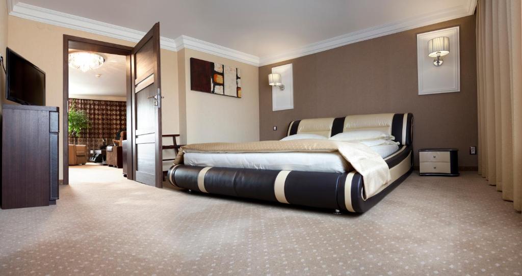 ein Schlafzimmer mit einem großen Bett in einem Zimmer in der Unterkunft M Hotel Sosnowiec in Sosnowiec