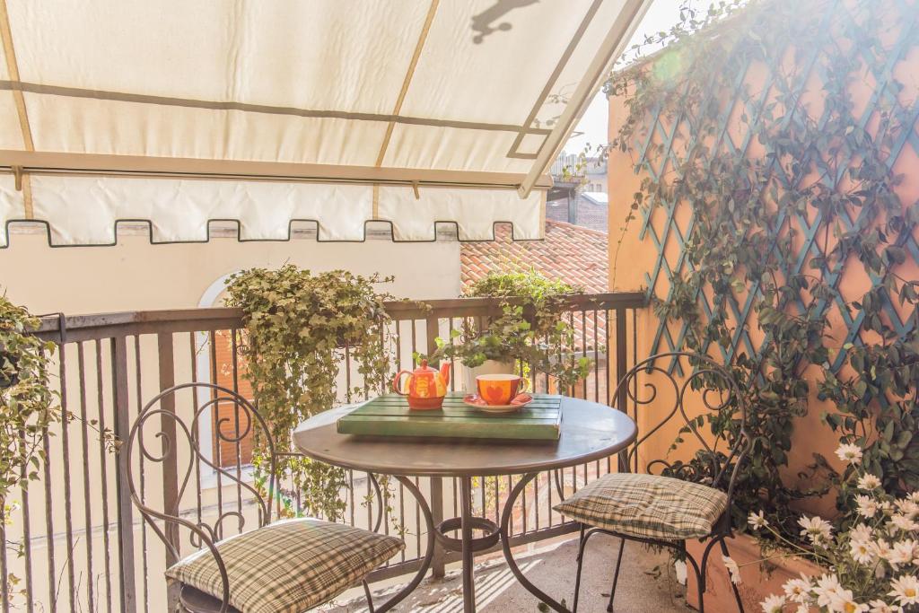 d'une petite table sur un balcon avec deux chaises. dans l'établissement Corso del Popolo Suite by Welc(H)ome, à Trévise