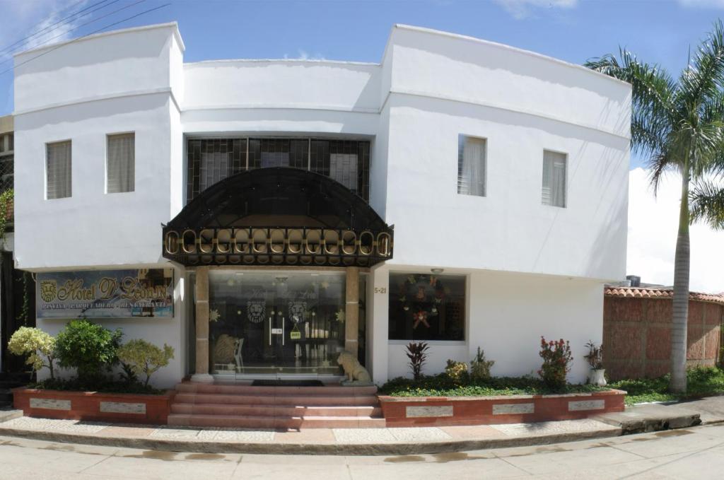 een wit gebouw met een winkel ervoor bij Hotel D' Leon Inn in Aguachica