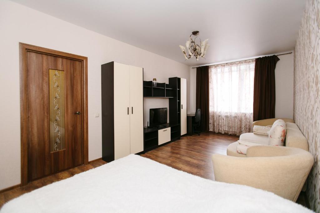 タンボフにあるApartment PrezentHaus Sovetskaya 190dのベッドとリビングルームが備わるホテルルームです。