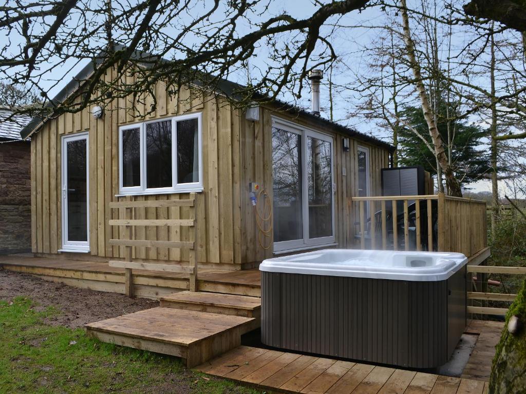 a tiny house with a hot tub on a deck at Treehouse Cabin in Westward