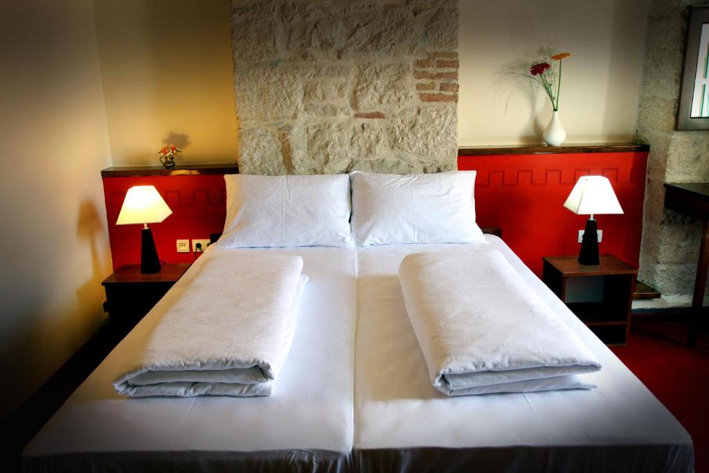 a bedroom with a large bed with white sheets and pillows at Hotel Carpymore in Biograd na Moru