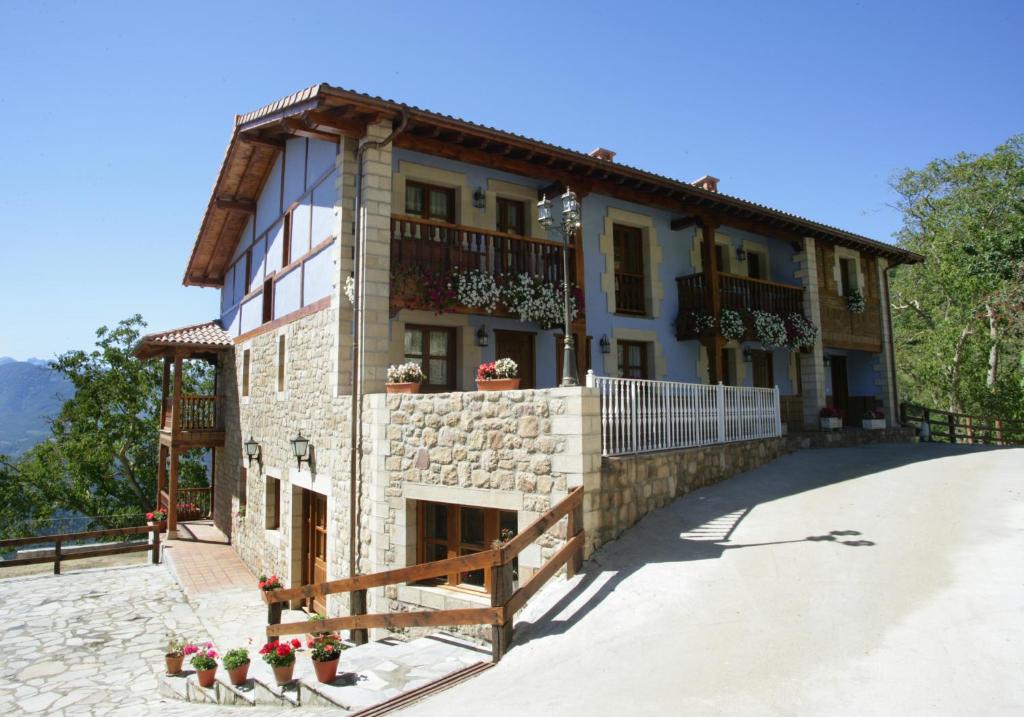 a building with a balcony on the side of it at Viviendas Rurales Peña Sagra in Cahecho