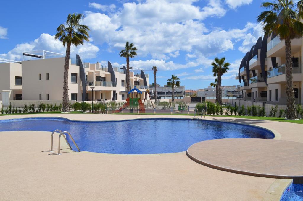 - une piscine avec une aire de jeux en face d'un bâtiment dans l'établissement Apartment Playa Elisa Bay, à Pilar de la Horadada