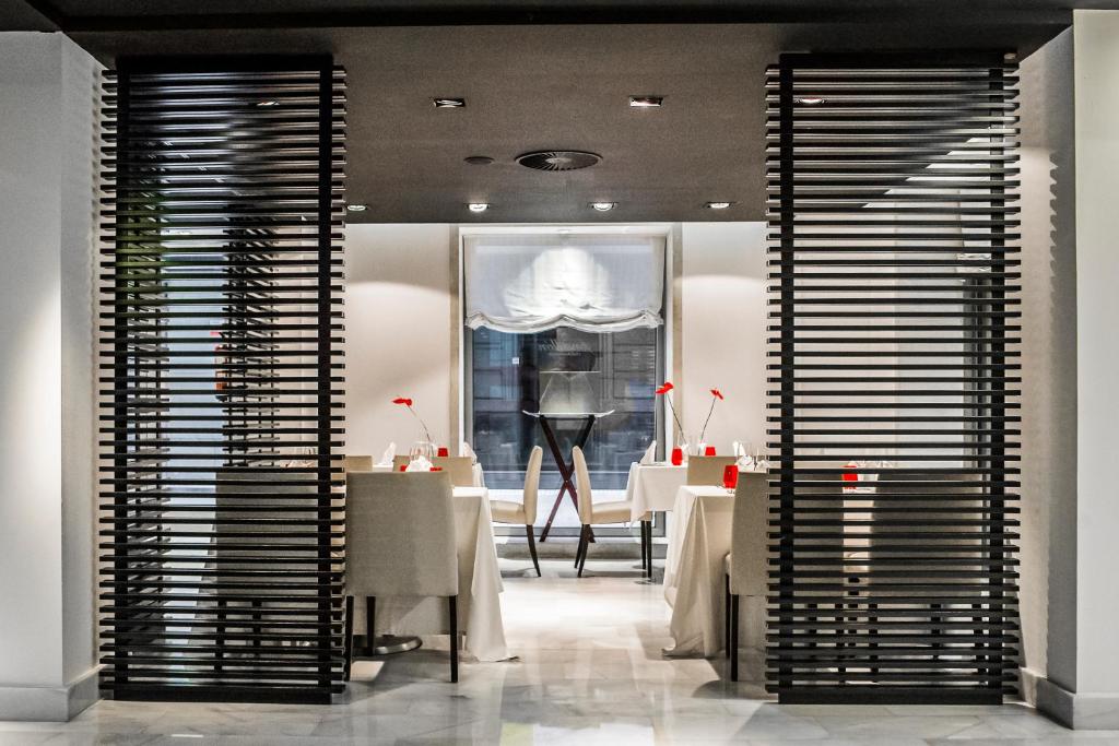 a dining room with tables and a large window at Hospes Amérigo, Alicante, a Member of Design Hotels in Alicante