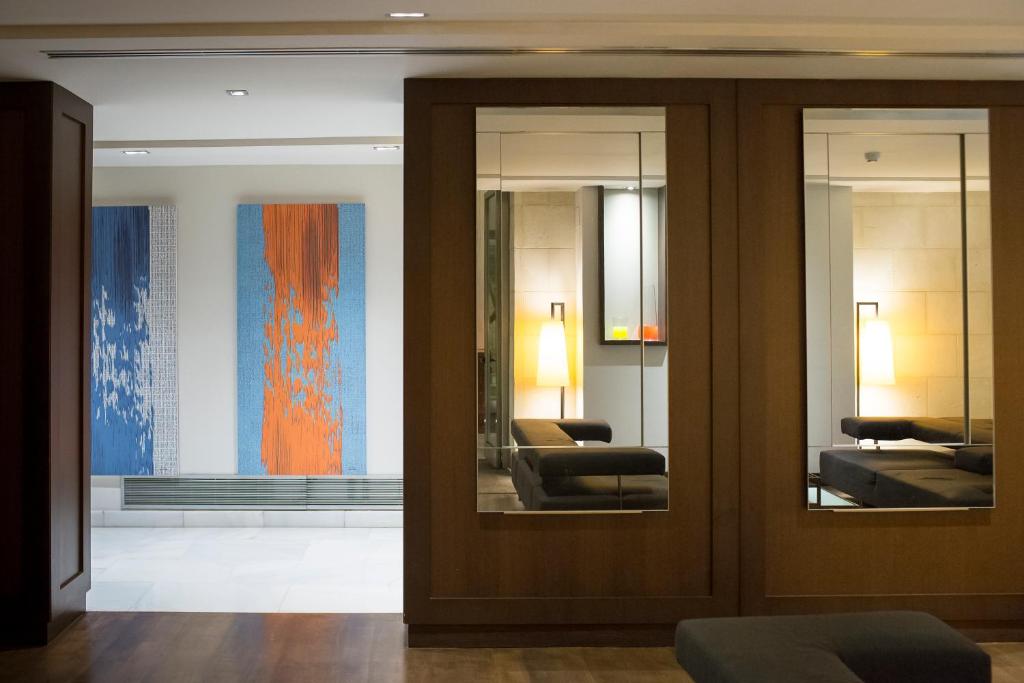 a lobby with two mirrors and two chairs in a room at Hospes Amérigo, Alicante, a Member of Design Hotels in Alicante