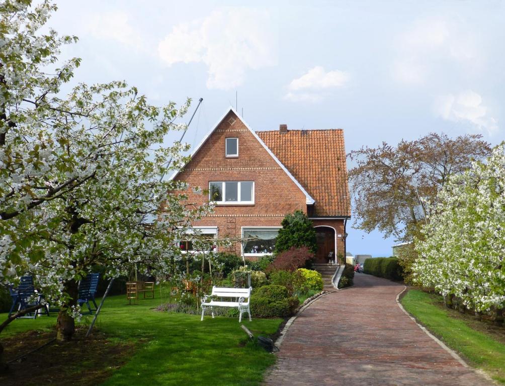 ein Backsteinhaus mit einer weißen Bank im Hof in der Unterkunft Pension Hauschildt in Jork