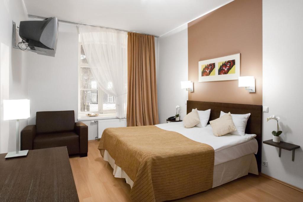 a hotel room with a bed and a chair at City Hotel Tallinn by Unique Hotels in Tallinn