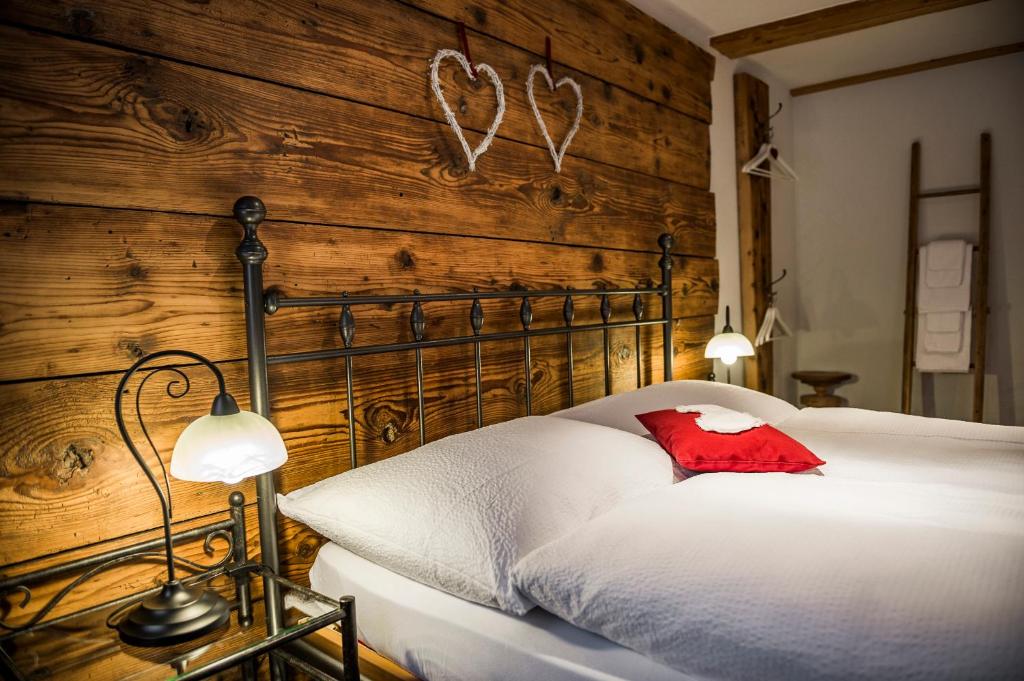 a bedroom with a white bed with a wooden wall at B3 Boutique-Bed&Breakfast in Gsteigwiler