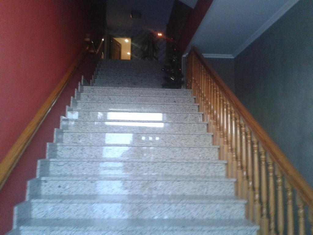 una escalera con escaleras de mármol blanco en un edificio en Hostal Texas 2 en Fuentes de Ebro