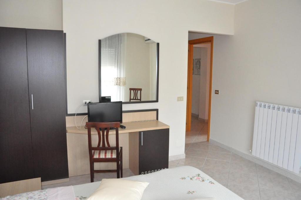 a bedroom with a bed and a desk with a television at Bed & Breakfast Oasi in Pescara