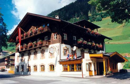 a large building with flowers on the top of it at Pension Kröll in Sankt Jakob in Defereggen