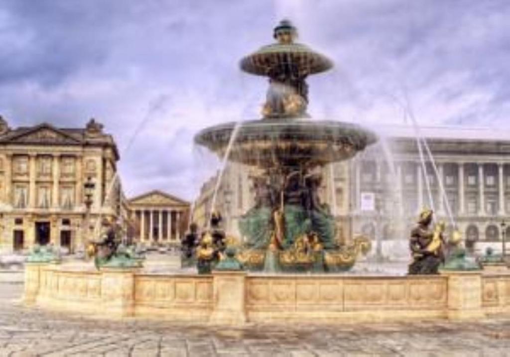 a fountain in a courtyard with people standing around it at Hôtel Royal Opéra in Paris