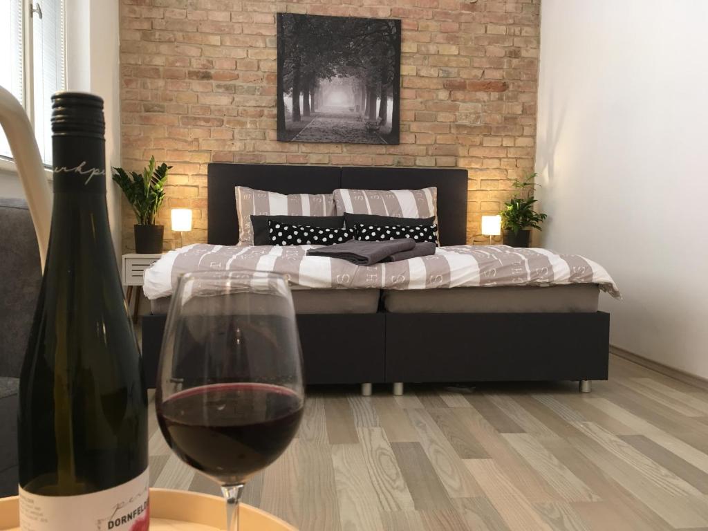 a bedroom with a bed with a glass of wine at Theresa Apartments in Litoměřice