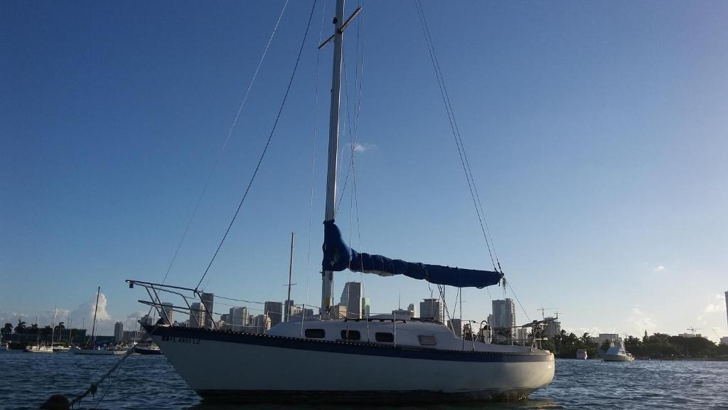 um barco na água com uma cidade ao fundo em Classic Sailboat 30’ em Miami