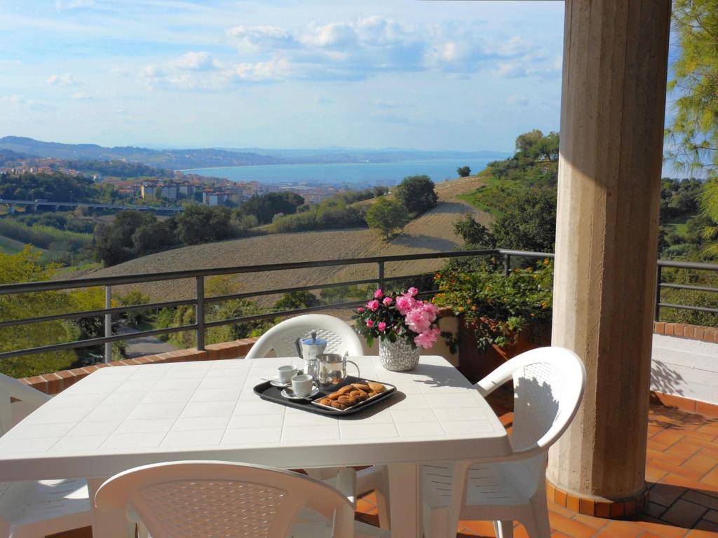 een witte tafel met een bord eten op een balkon bij Fiori del Conero in Ancona