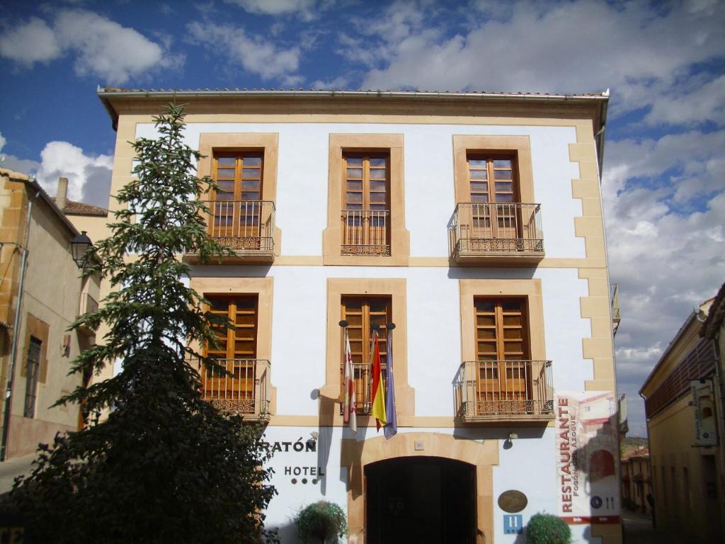 ein weißes Gebäude mit Balkonen und einem Baum in der Unterkunft Hotel Rural Vado del Duratón in Sepúlveda