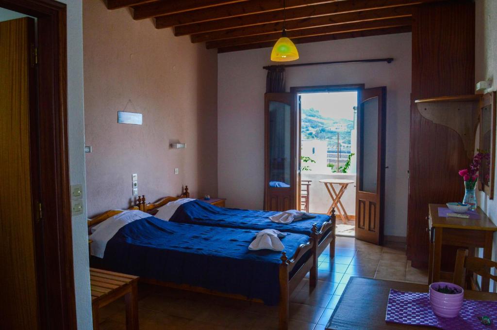 a bedroom with a blue bed and a balcony at Romantza in Skala