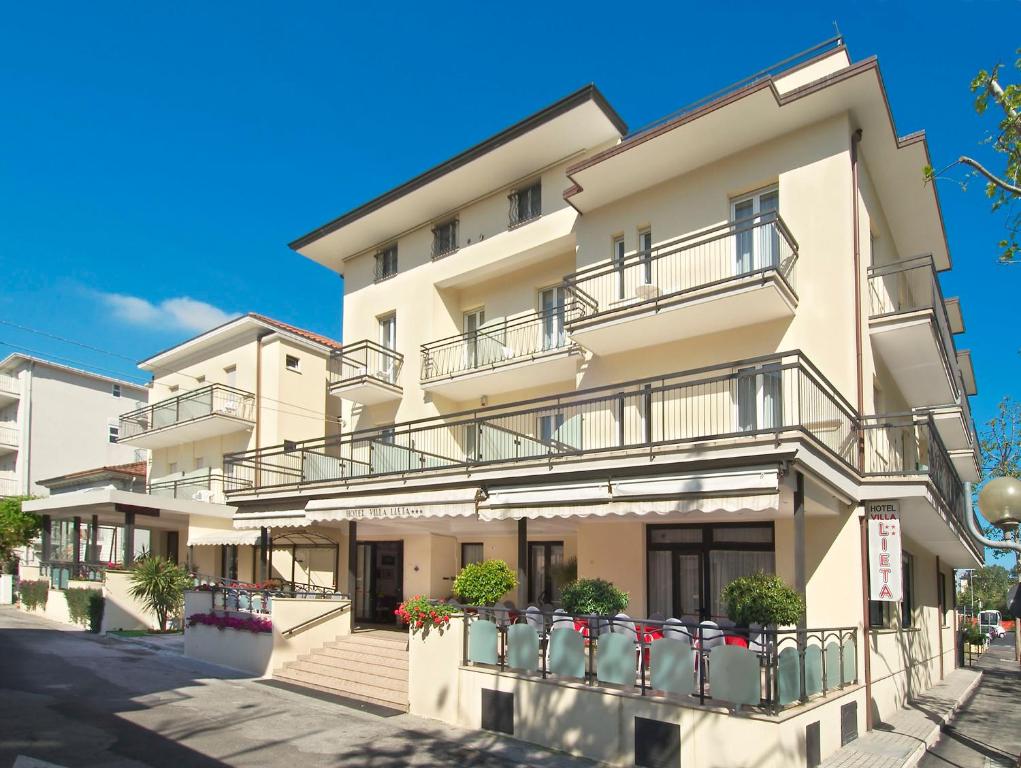 un condominio con balconi e fiori su una strada di Hotel Villa Lieta a Rimini