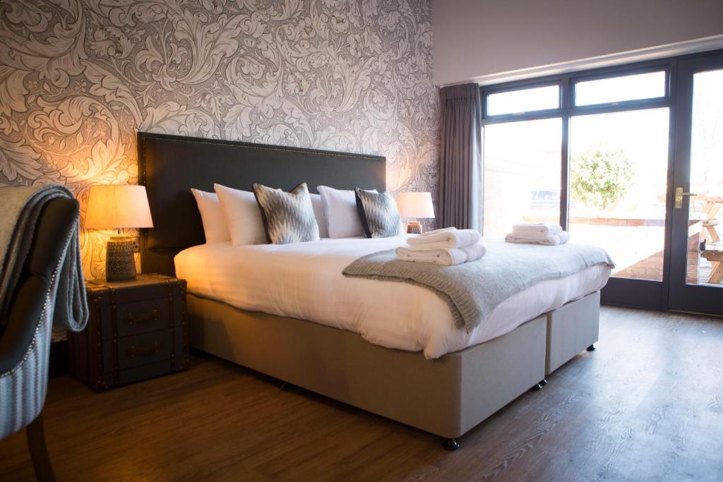 a bedroom with a large bed with two towels on it at Wynnstay Arms, Ruabon, Wrexham in Ruabon