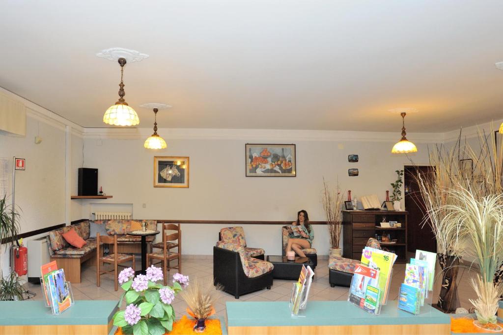 a living room with two people sitting in chairs at Hotel Lidia in Alba Adriatica