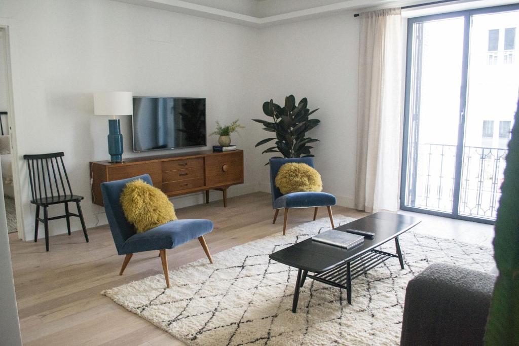 sala de estar con 2 sillas y TV en Exclusivo en Barrio de Salamanca en Madrid