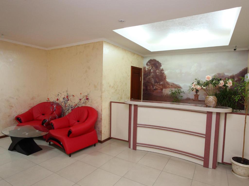 een woonkamer met een rode stoel en een tafel bij Paradise Hotel in Svitlovodsʼk