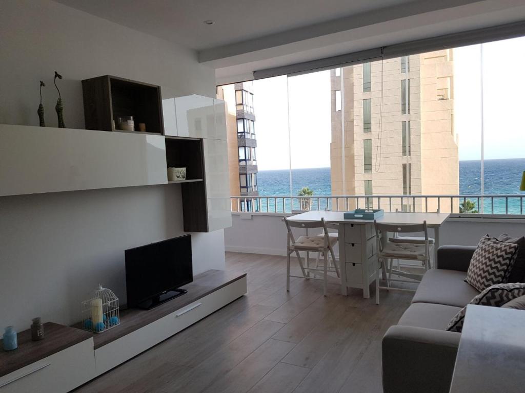 a living room with a couch and a television and a table at BlancMar Apartament in Calpe