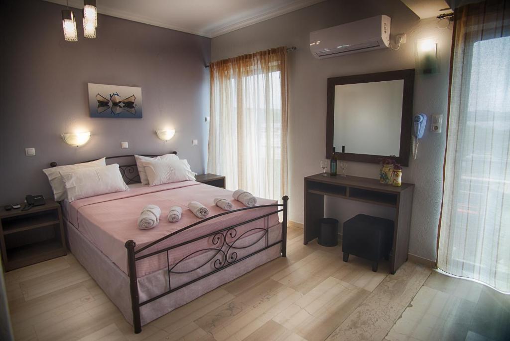 Dormitorio con cama con espejo y tocador en Galazio Limani - Rooms to let en Moudhros