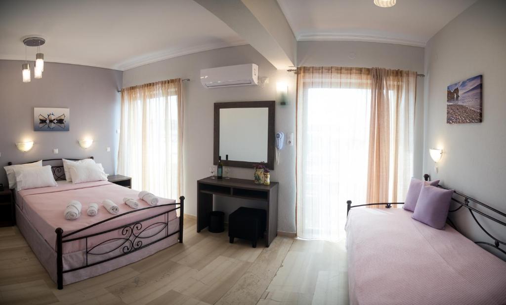 a bedroom with a large bed and a mirror at Galazio Limani - Rooms to let in Moúdhros