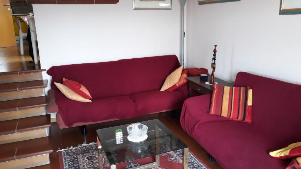 a living room with a red couch and a coffee table at La Contessa (Da Fabiola) in Urbino