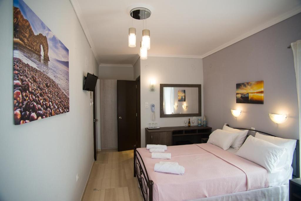 a bedroom with a large bed with towels on it at Galazio Limani - Rooms to let in Moúdhros