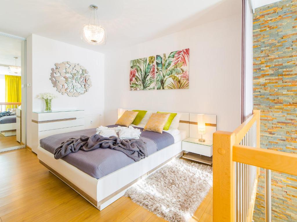 ein Schlafzimmer mit einem Bett und einer Ziegelwand in der Unterkunft Apartament Kristina Osiedle Polanki in Kołobrzeg