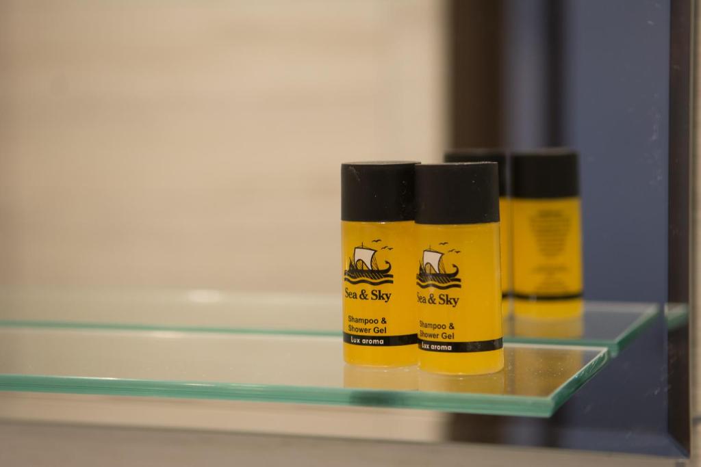 two bottles of disinfectants sitting on a glass shelf at Galazio Limani - Rooms to let in Moúdhros
