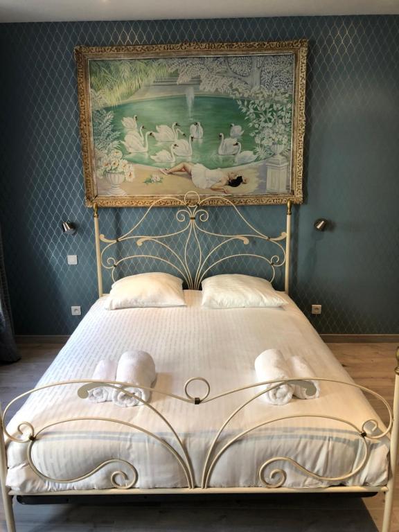ボーヌにあるCocoon amoureux de Beauneの壁に絵画が描かれたベッドルームのベッド1台