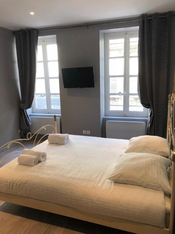 a bedroom with a large bed with two towels on it at Cocoon amoureux de Beaune in Beaune