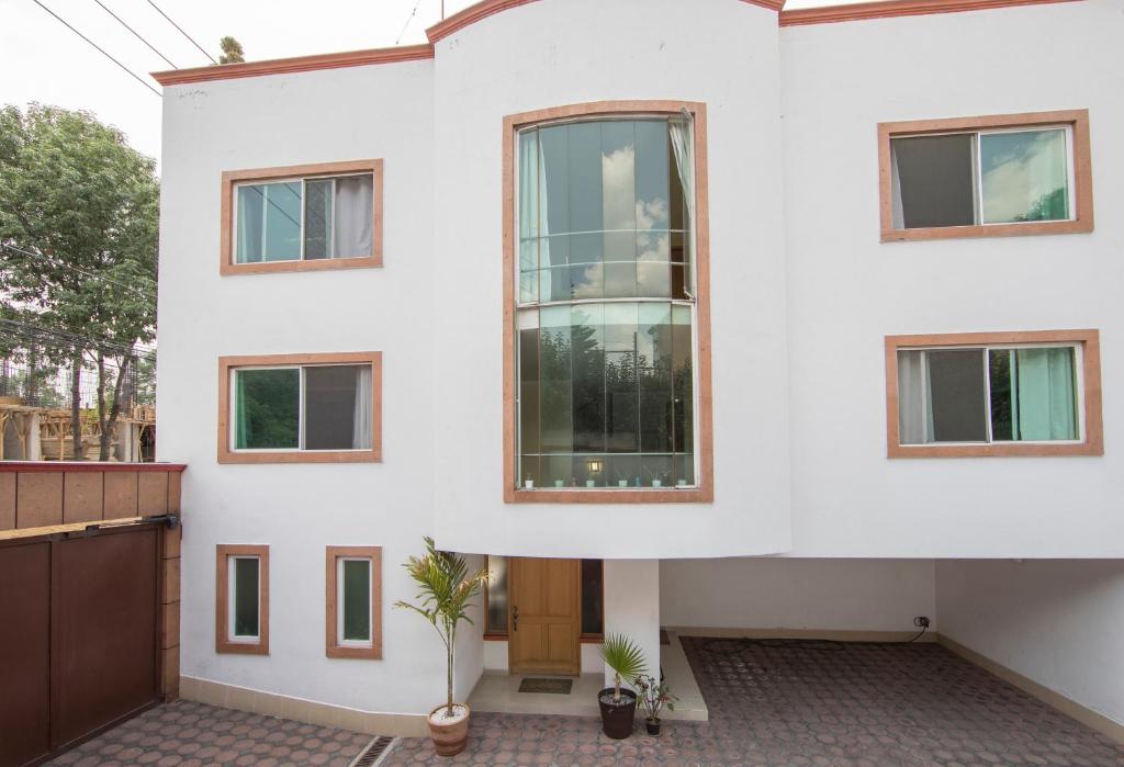 a white house with windows and a door at Casa Hidalgo En El Corazón de Coyoacán in Mexico City