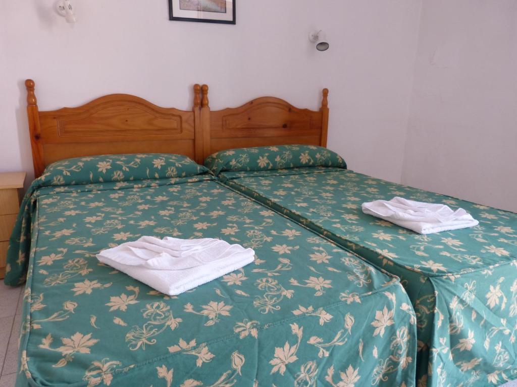 a bed with two towels sitting on top of it at Hotel German in Vilaflor