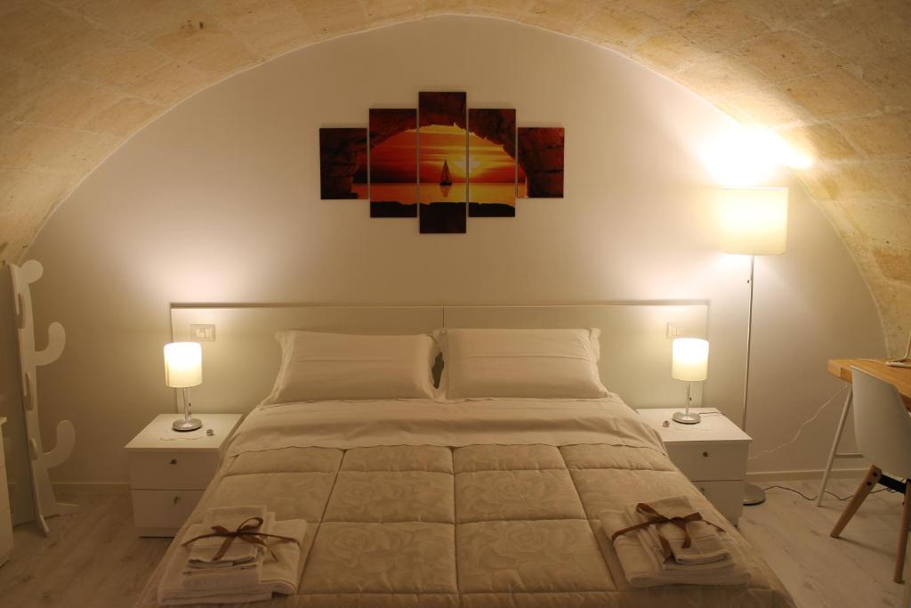 sypialnia z łóżkiem z dwoma lampami i obrazem na ścianie w obiekcie Lorenzo il magnifico w mieście Matera