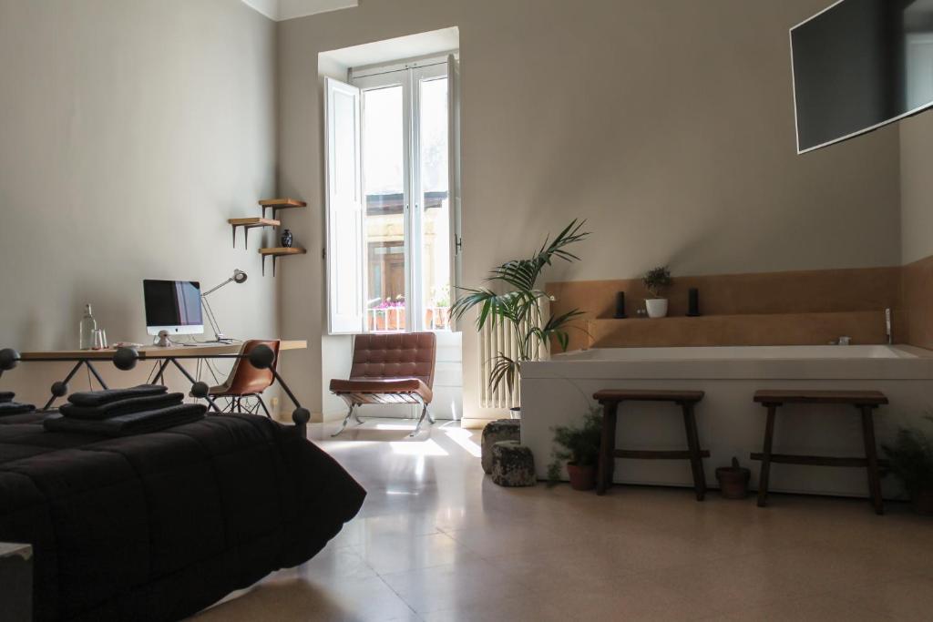 uma sala de estar com um sofá, uma mesa e uma cozinha em 4 Balconi rooms-Boutique B&B em Lecce