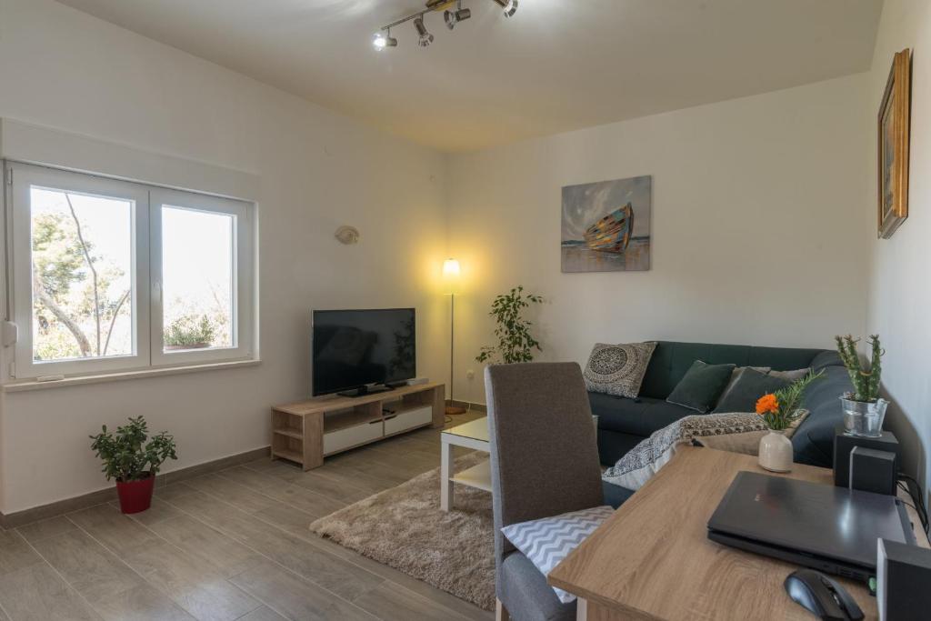 ein Wohnzimmer mit einem Sofa und einem TV in der Unterkunft Apartment Okrug Gornji - Trogir with Sea View in Trogir
