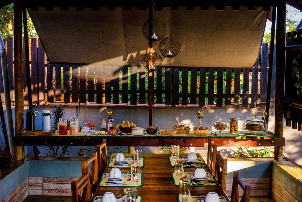 Pousada Nativos في ميراندا: مطعم فيه طاولات وكراسي في الغرفة
