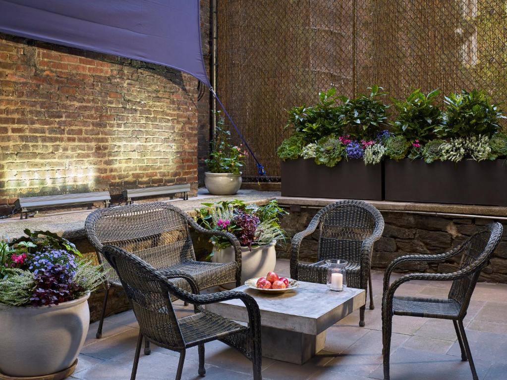 un patio con sillas, mesa y plantas en Seton Hotel, en Nueva York