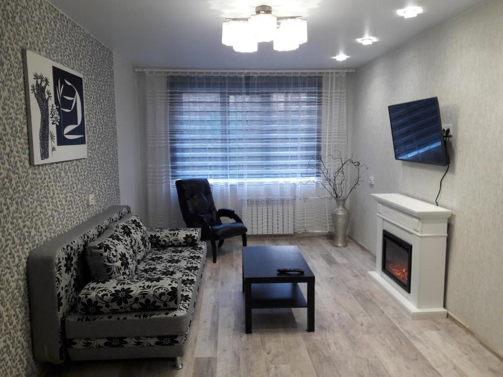 ハバロフスクにあるАпартаменты с 2-мя спальными и гостинной на Ким Ю Чена 9аのリビングルーム(ソファ、椅子、暖炉付)