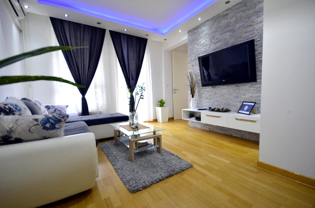 a living room with a couch and a flat screen tv at Clean&Cozy Apartments Novi Beograd in Belgrade